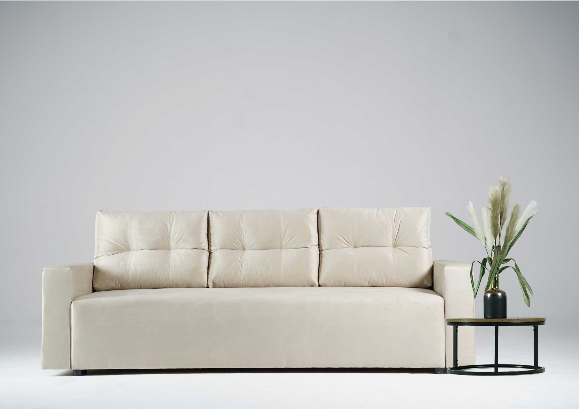 Beżowa kanapa z pikowanymi poduszkami